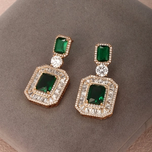 Macro detail of emerald cut green crystal earrings with sparkling pave zircon settings