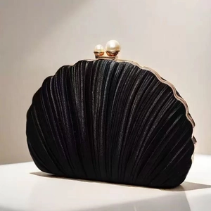 Dettaglio ravvicinato della borsa da sera a conchiglia con texture a pieghe e perle