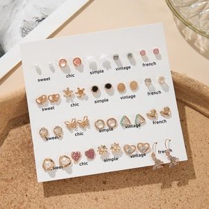 20 pairs of fashion gold earrings set with pearls, hearts, and rhinestones on white card
