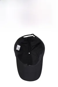 Interior view of breathable black cotton baseball cap showing wash label and strap