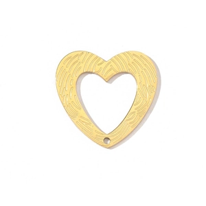Macro detail of golden heart pendant with wood grain texture and bottom connector hole
