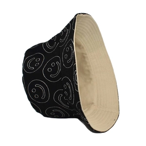 Detailed embroidery of white smiley faces on a stylish black canvas bucket hat