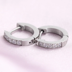 Macro detail of silver stainless steel hoop earrings with clear cubic zirconia pavé