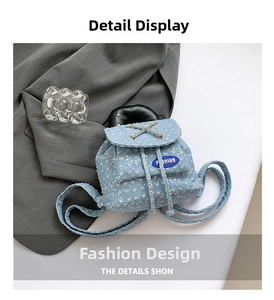 Detail of light blue denim mini backpack featuring sequin flowers and drawstring closure