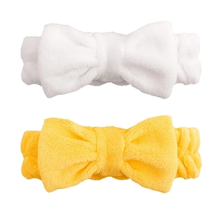 Detail of plush coral fleece spa headbands with bow ties in pearl white and bright yellow