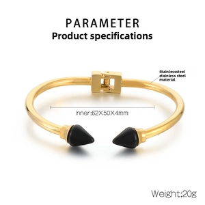Detail view of gold stainless steel bangle with black spike ends and spring hinge mechanics