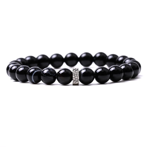 Macro detail of polished black agate beads with silver textured metal spacer bead