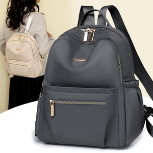 Detail of waterproof nylon backpack showing metallic zippers and front zip pocket