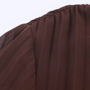 Detailed close-up of dark brown pleated chiffon fabric with precise stitching details