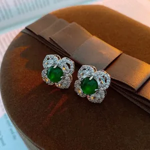 Silver needle flower earrings with white zircon petals and green gemstone center