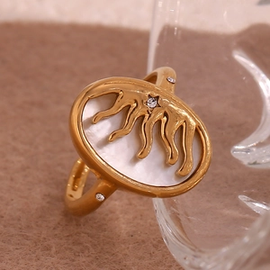 Detail of 18K gold plated ring with sun motif on white shell and clear gems