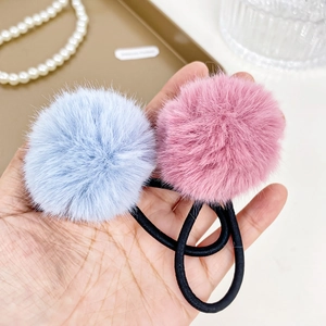 Plush cream pompom hair ties in blue and pink on high-elastic black rubber bands