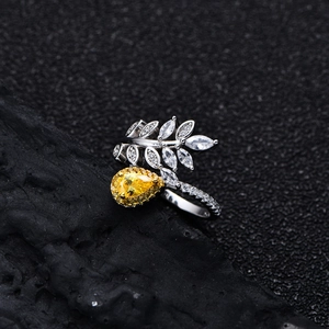 Leaf design 925 silver ring with a yellow pear-cut gemstone on dark rock background