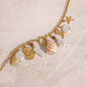 Collana nautica dorata con stella marina, conchiglia e perle bianche irregolari
