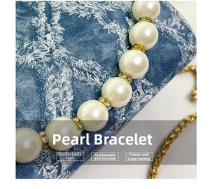 Detail of luxury pearl strap with gold crystal spacers on blue denim bag fabric