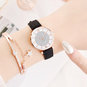 Detail van roségouden strass horloge met zwarte band en bijpassende sterrenarmband