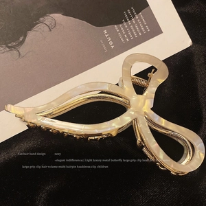 Detail of a large butterfly hair claw with cream acetate and sparkling rhinestone edge