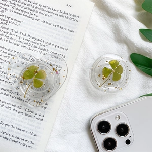 Detailed close-up of resin phone grips featuring clover and gold foil inside