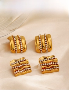Détail de boucles d'oreilles dorées à motifs ondulés carrés et zircons blancs incrustés