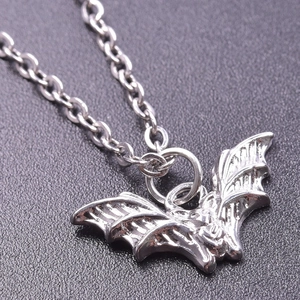 Detailed macro view of a silver stainless steel bat pendant on a link chain necklace