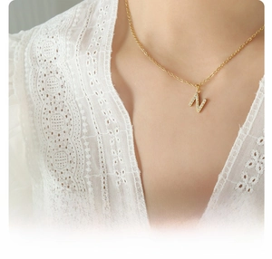 Detailed shot of 18k gold plated titanium steel letter N pendant necklace with zircons