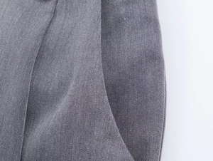 Détail du tissu en sergé gris et couture de la poche sur un costume tailleur pour femme