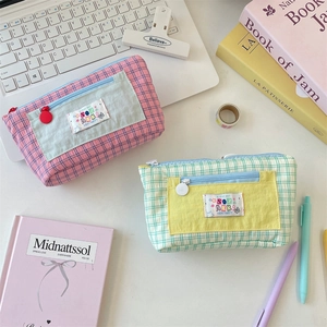 Close-up of pink and green plaid canvas pencil cases with multi-layer zipper storage