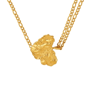 Collar de doble cadena dorada con colgante de hoja de textura irregular en fondo blanco