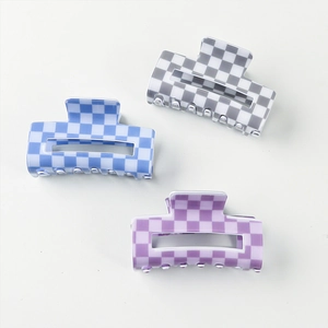 Lot de trois pinces à cheveux à damier bleu, gris et violet sur fond blanc