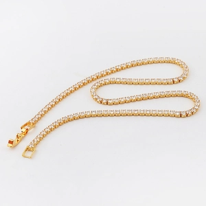 Macro shot of gold tennis necklace with square zircons arranged in a heart shape