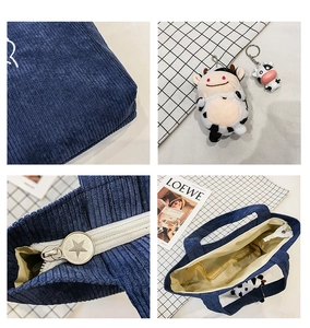Detail of navy corduroy tote with cow charms and metallic star zipper slider