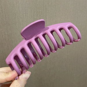 Primer plano de una pinza para el pelo grande de color púrpura mate con agarre firme