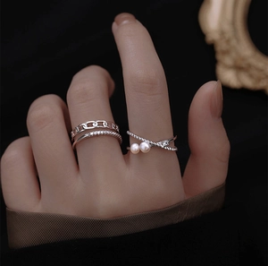 Close-up of silver-toned double-layer chain ring with zircons and pearl cross ring