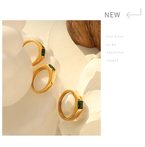 Detailed view of three 18K gold plated titanium rings with emerald-cut green zircon stones