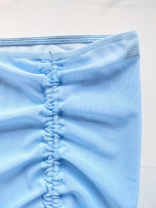 Détail du tissu en maille bleu clair avec effet froncé et coutures professionnelles