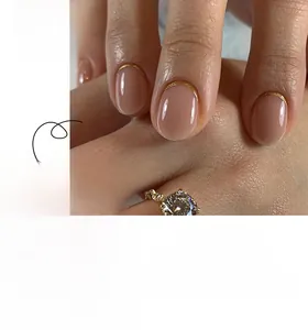 Detail of short oval french press-on nails with nude pink base and gold crescent edges