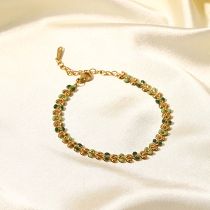 18K gold stainless steel bracelet with green enamel olive leaf charms on silk background