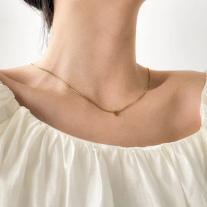Minimalist gold plated titanium steel moon pendant necklace worn by a fashion female model