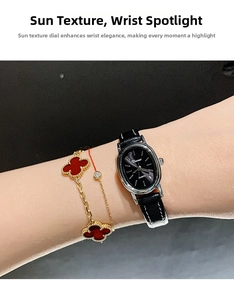 Detail of vintage oval quartz watch with black sunray dial and leather strap on wrist
