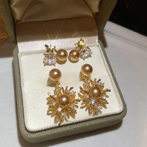 Dettaglio di orecchini a fiore e farfalla placcati oro 18K con perle e zirconi