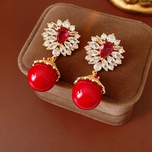 Vue macro de boucles d'oreilles vintage en or avec gemmes rouges sur une boîte à bijoux