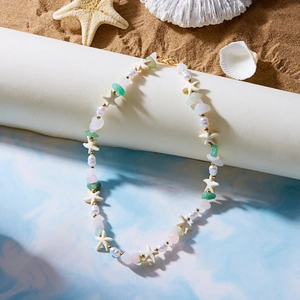 Bohemian natural stone necklace with starfish beads on a beach sand background
