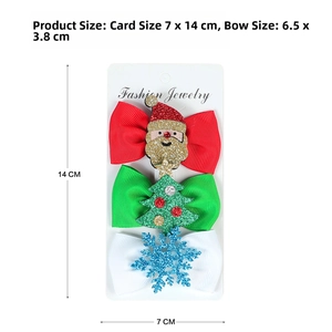 Detailed view of three Christmas bow hair clips with glitter accents on a display card