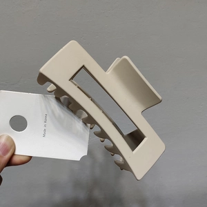 Detail of a large beige square cutout hair claw clip with a Korean minimalist style design