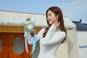 Detail of mint green telephone-shaped kids water bottle with fruit stickers and colorful strap