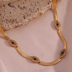 Detail of 18K gold-plated snake chain featuring evil eye charms with black stones