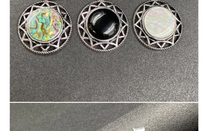 Detail of round silver pendants with abalone shell, onyx, and mother of pearl inlay