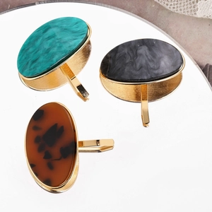 Oval marble and tortoiseshell pattern hair hooks with gold metal base on mirror