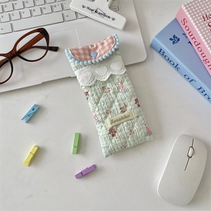 Detailed shot of quilted cotton glasses case with lace trim and heart button closure