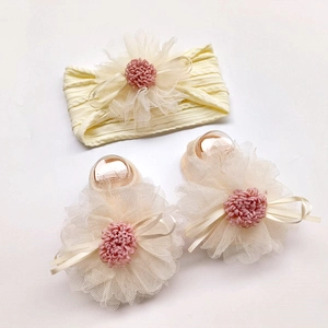Close-up of beige baby headband and socks set with large chiffon floral decorations